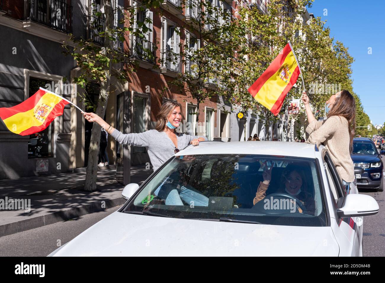 Madrid, Spain, 12th oct 2020.  Two girls proudly waving flag as they attend a protest against Spanish government's handling of the COVID-19 crisis. Stock Photo