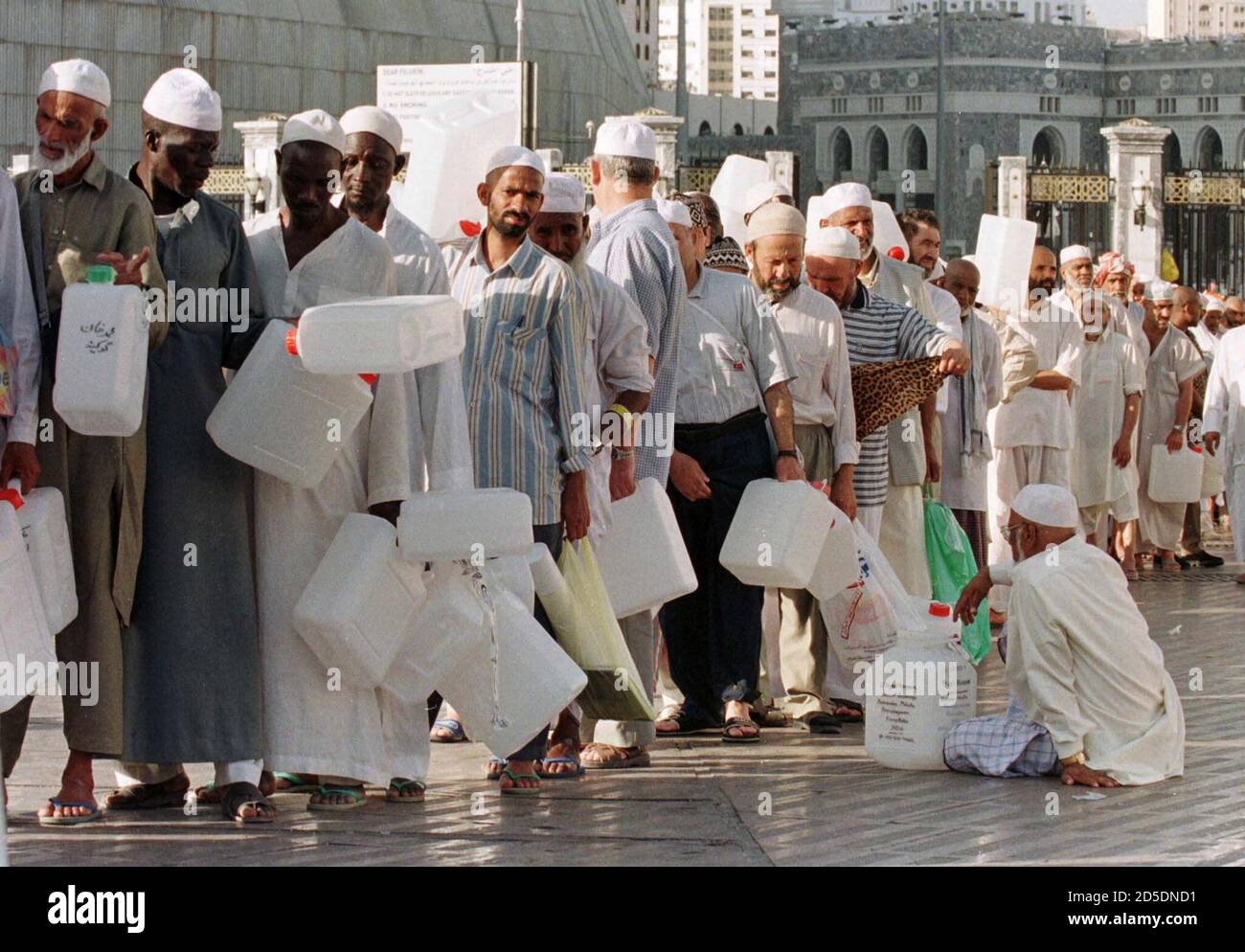 Pilgrims wait in a queue for holy water Zam Zam in front of the Al