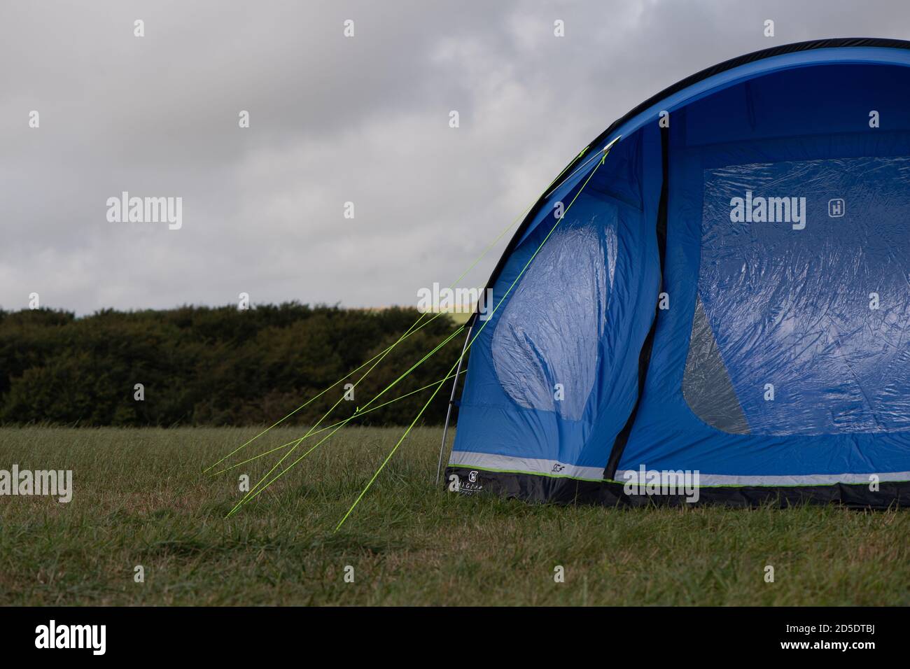 A single modern blue tent with different crops and angles in a field with copy space to use in camping stories Stock Photo