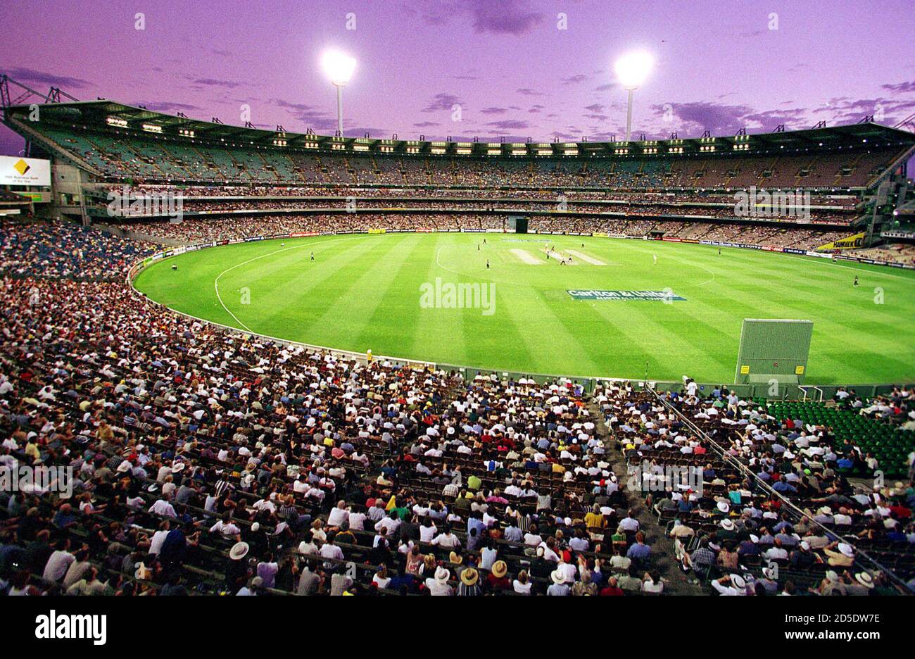 Spectators At The Melbourne Cricket Ground Mcg Watch A Day Night Cricket Match Under Lights With The Stadium S Southern Stand In The Background The Mcg Will Be A Venue For Soccer Matches For