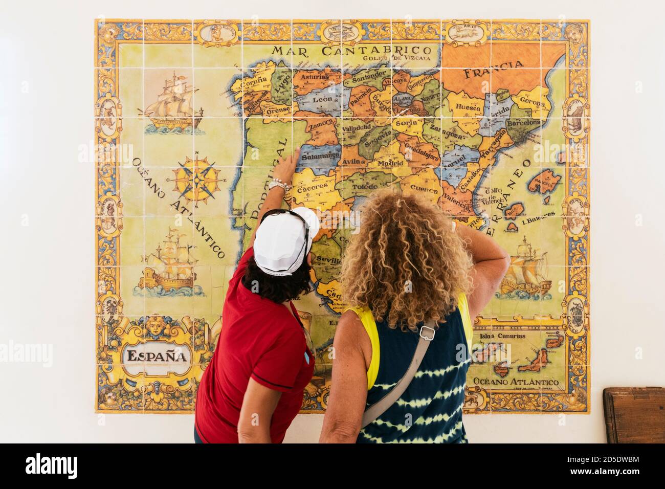 Visitors studying ceramic tiled map of Spain showing provinces, oceans and neighbouring countries.  It is on display at the ticket and information off Stock Photo