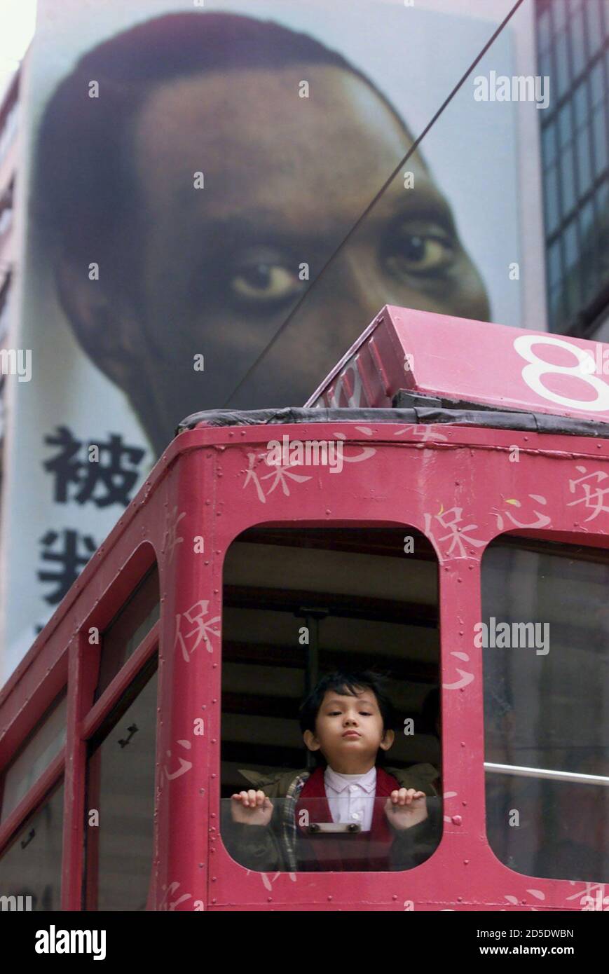 A boy looks out from a tram in front of part of a controversial death row  advertising campaign from Benetton, newly presented in Hong Kong, February  24. The Italian clothing company defended