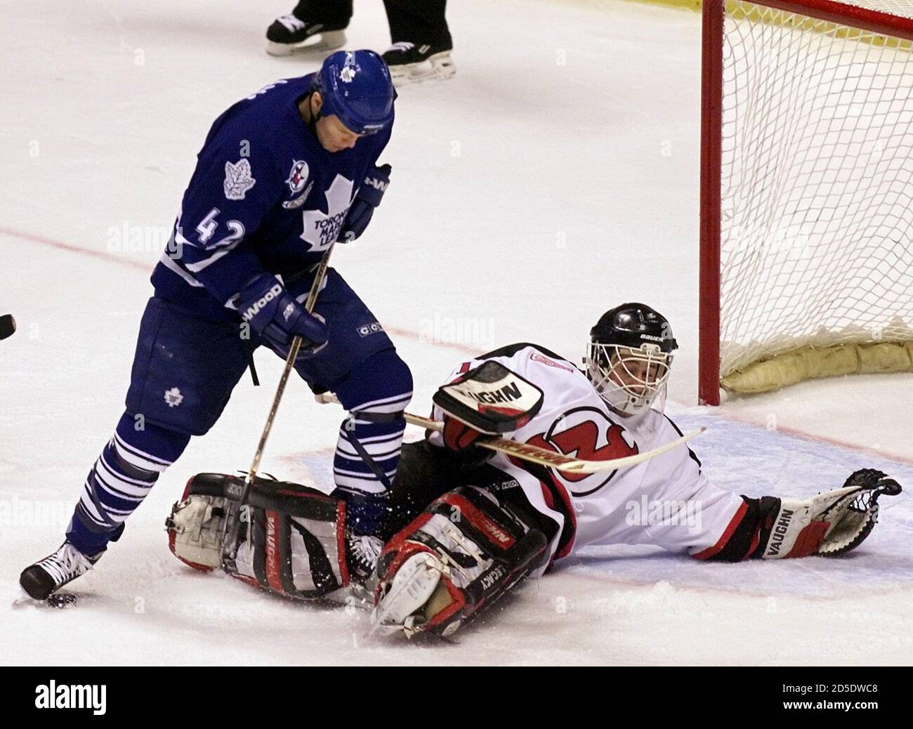 New Jersey Devils goalie Chris Terreri (R) is down but manages to kick away  the rebound on a scoring attempt by Toronto Maple Leafs center Kevyn Adams  (42) in the first period
