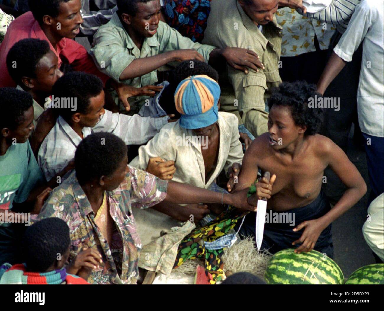 A Somali woman tries to defend her self with a knife she picked up from a melon stand after mobs attacked her in Mogadishu December 14. She was accused of spending the night with a French soldier taking part in Operation 'Restore Hope'. Stock Photo
