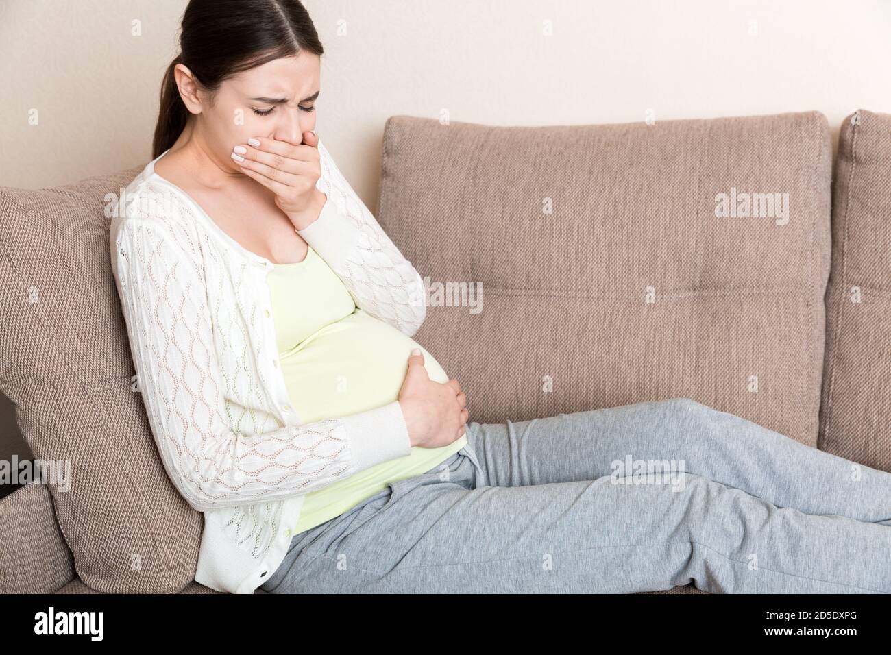 Pregnancy Morning Sickness. Pregnant Woman Having Nausea Feeling Bad in Sofa at the Home. Stock Photo