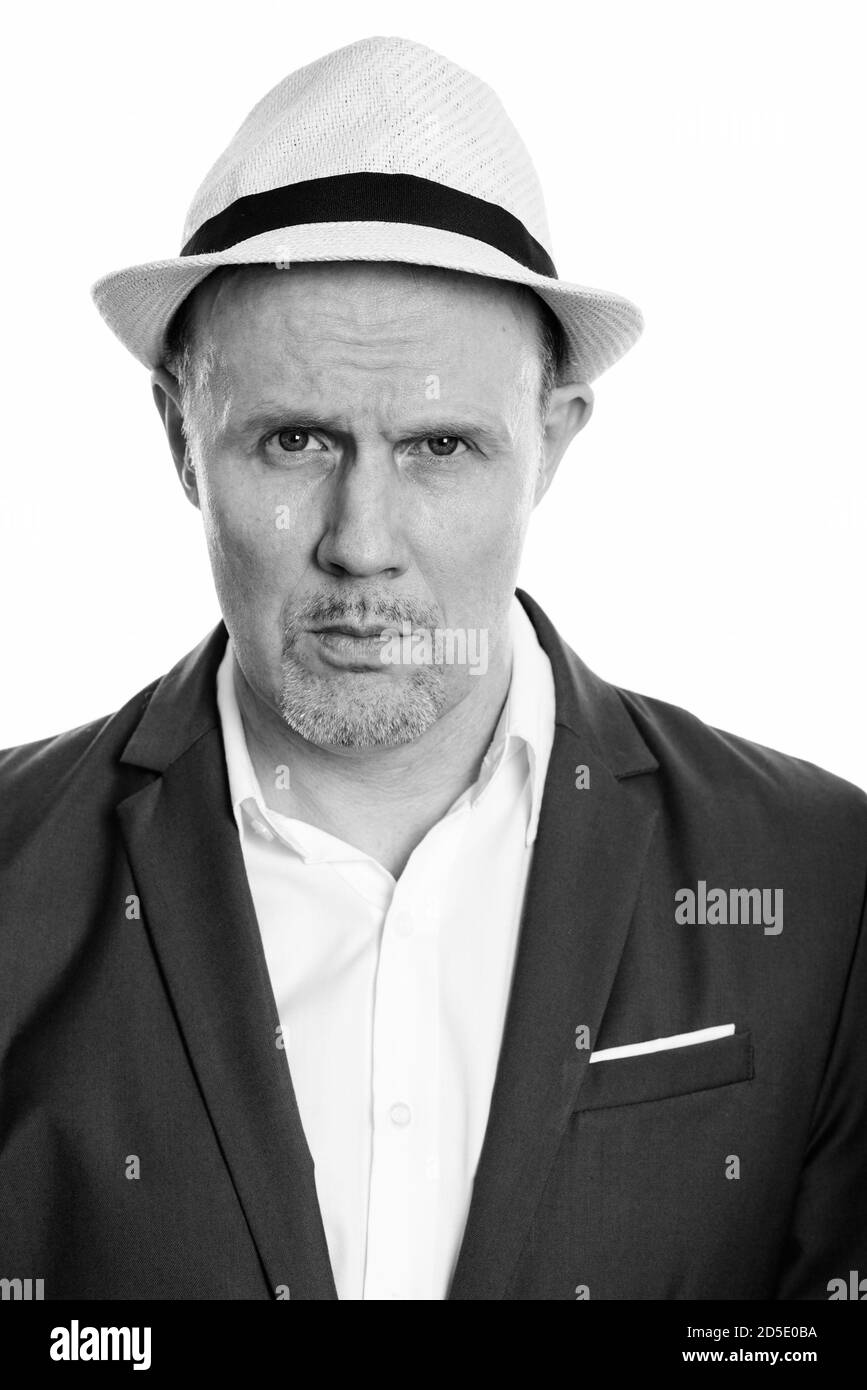 Face of mature businessman wearing suit and hat Stock Photo