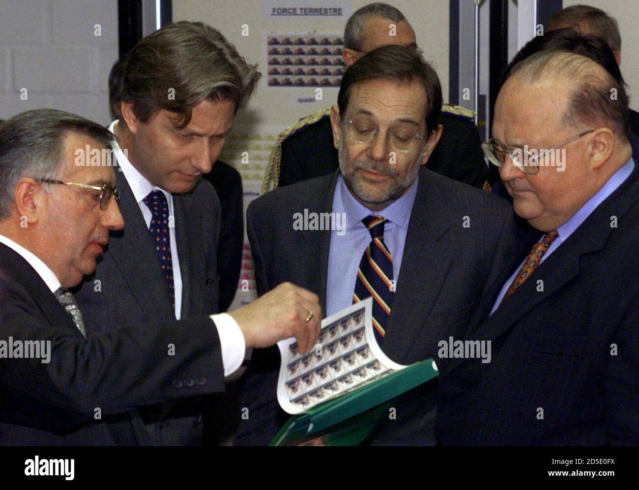 L-R) The head of Belgium's stamp printing office, Jean Wauters, shows  samples of new postage stamps commemorating NATO's 50th anniversary this  year to Belgium's Prince Philippe, NATO Secretary General Javier Solana and