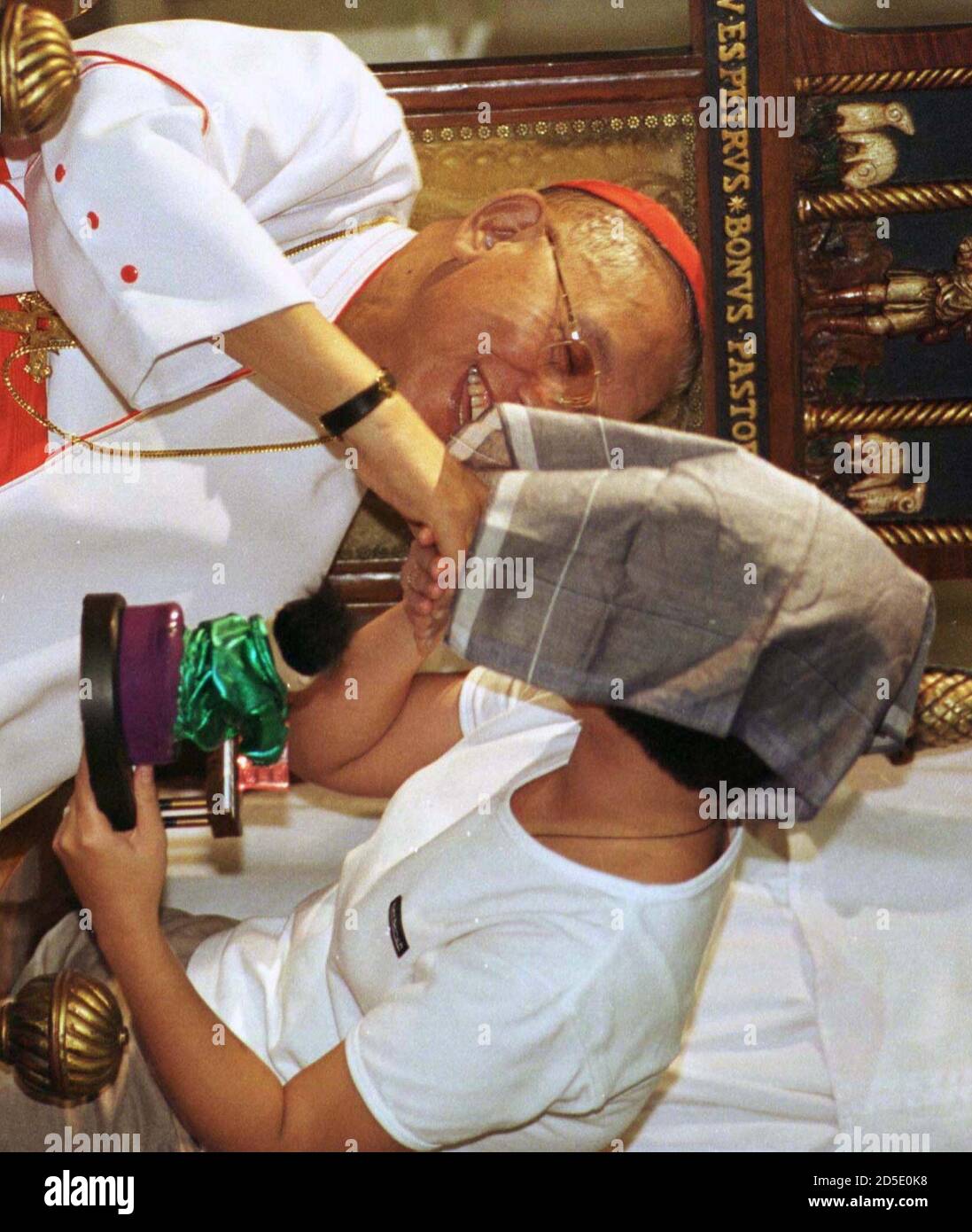 Baby The Step Daughter And Rape Victim Of Leo Echegaray A Philippine Man Awaiting Execution For Child Rape Kisses The Hand Of The Archbishop Of Manila Cardinal Jaime Sin After Mass In Manila