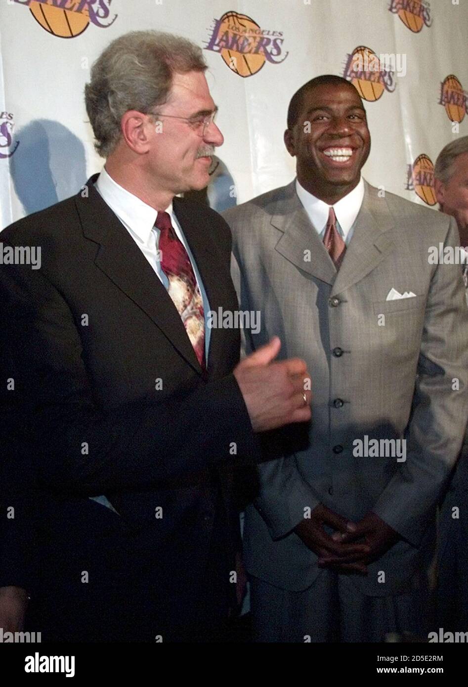 Newly named Los Angeles Lakers coach Phil Jackson (L) speaks to a smiling Magic  Johnson as they pose for pictures a press conference June 16 in Beverly  Hills. Jackson brings his experience