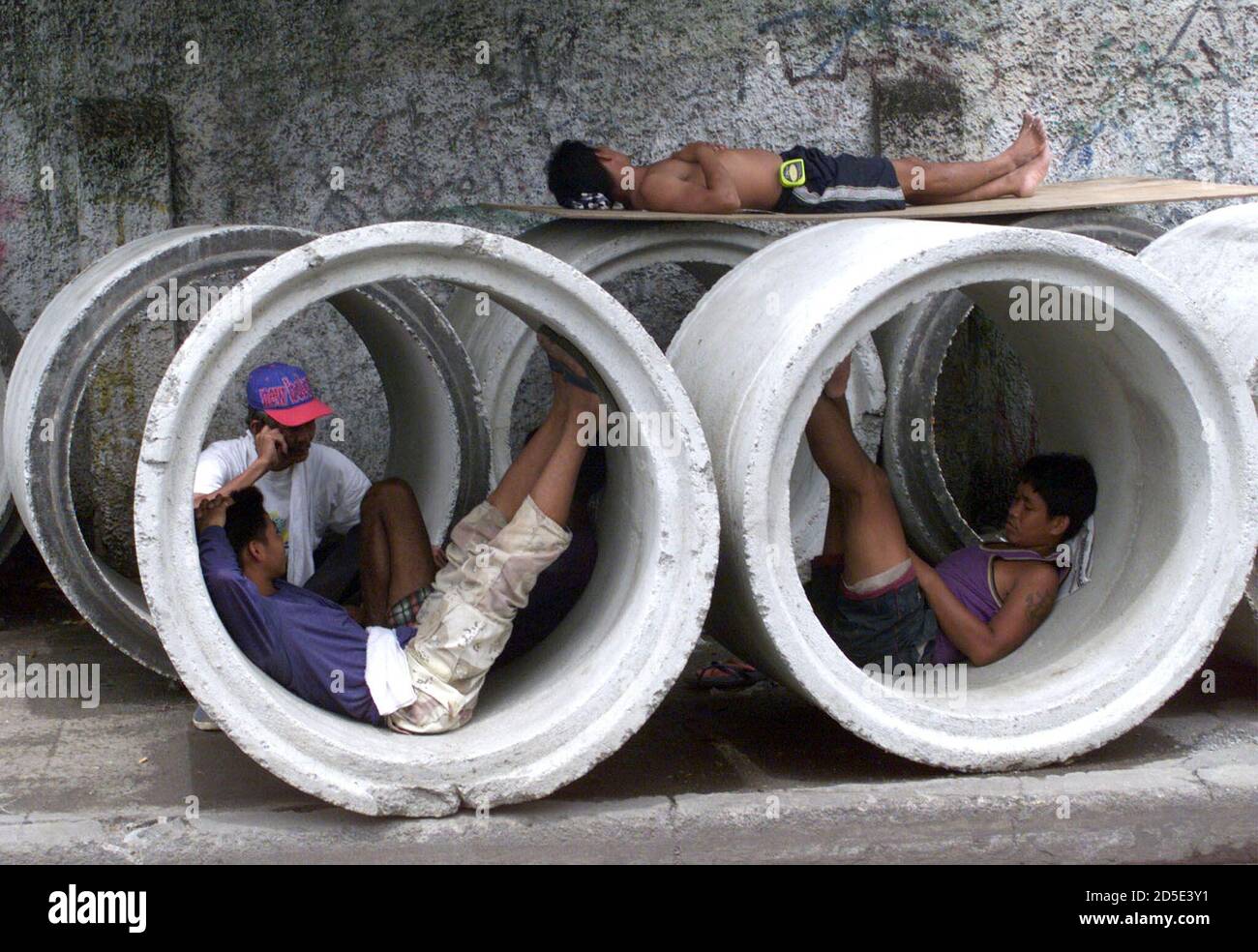 Filipino construction workers take a break inside culverts they are  installing in the Philippine capital Manila September 30. These labourers,  like other Filipino workers in the capital, earn a minimum wage of