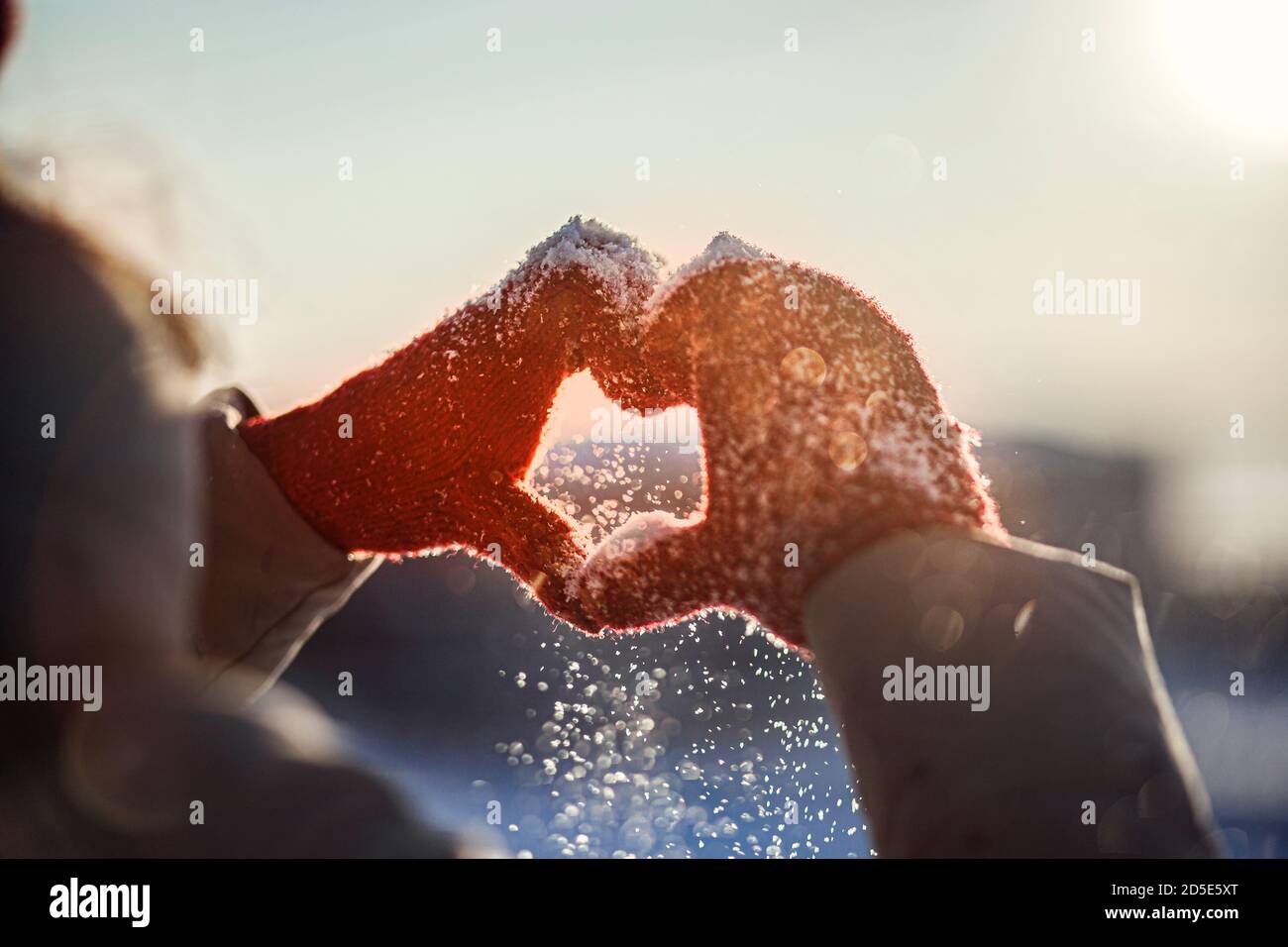 Heart shape symbol of the women's mittens in winter frosty sunset. Concept of frosty winter, dating, valentines day and love. Stock Photo