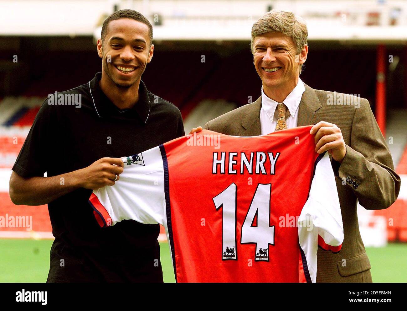 French international striker Thierry Henry (L) smiles with manager Arsen  Wenger as they show off his new number 14 Arsenal shirt at Highbury August  3. Henry aged 21 was signed for an