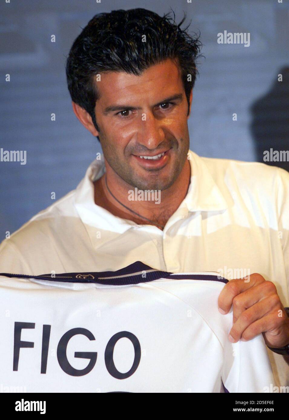 Portuguese player Luis Figo holds a Real Madrid shirt at his presentation  in Bernabeu stadium July 24. Figo, who will become the world's most  expensive player when Real paid the $56.1 million