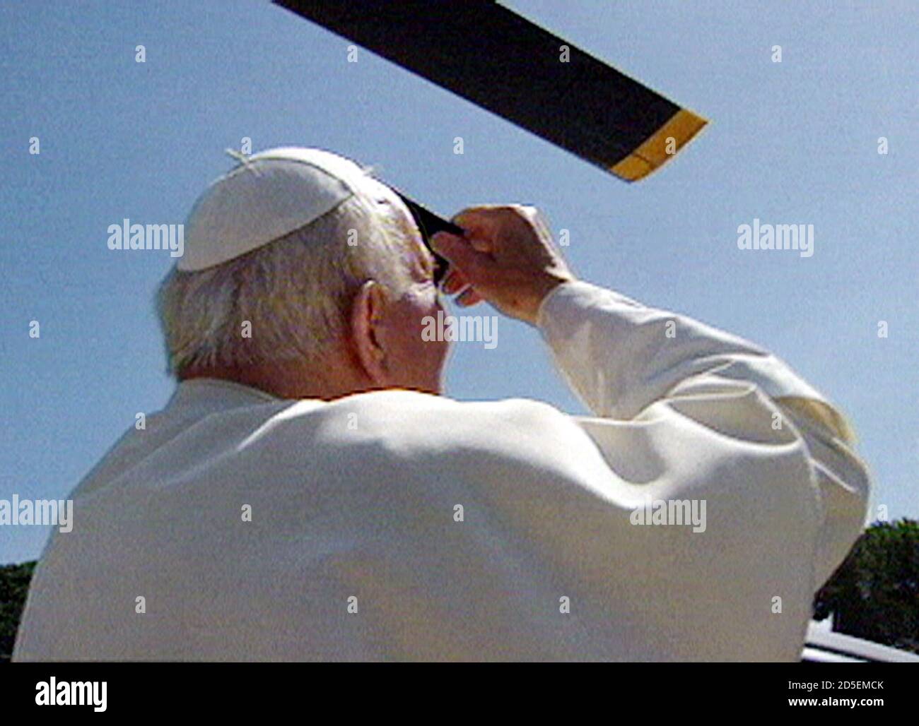 Pope John Paul II uses a filter of tinted glass to get a glimpse of the solar eclipse August 11. The Pope cut short his weekly audience to be sure not to miss the event. Stock Photo