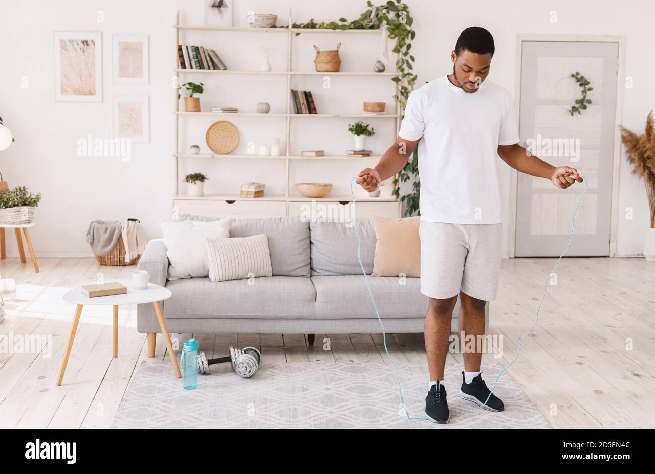 African American Guy Holding Jumping Rope Exercising Standing At Home