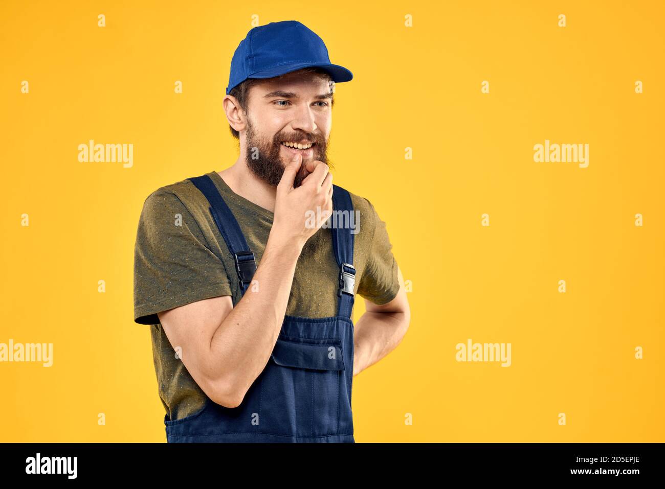 Worker man in uniform worker service yellow background emotion Stock