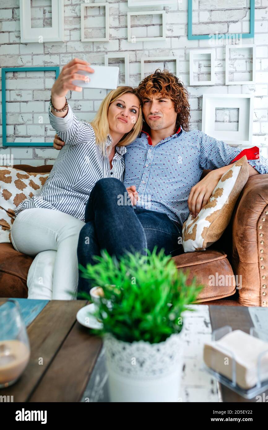 Couple taking selfie on a sofa Stock Photo