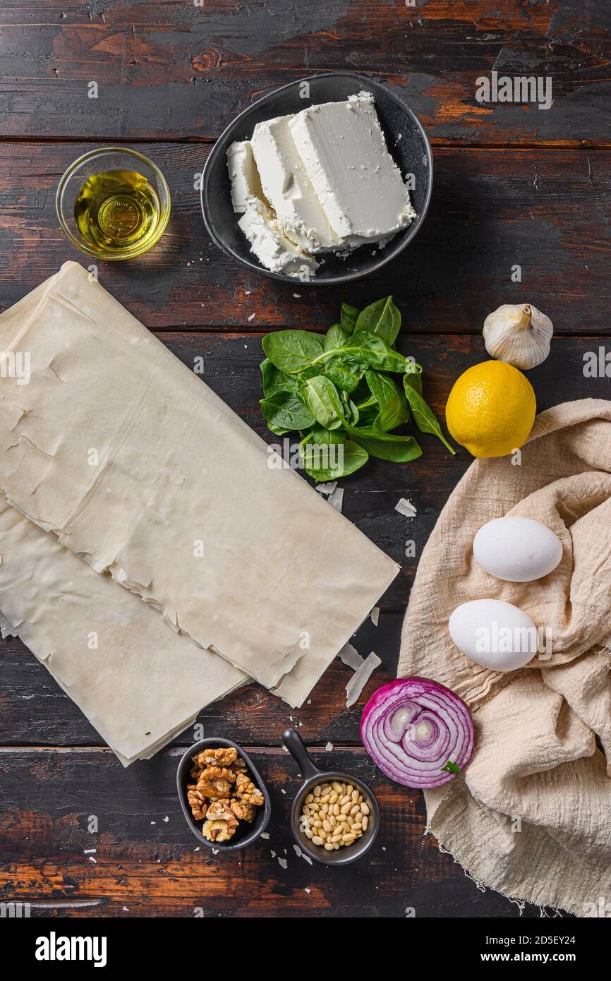 Greek spanakopita ingredients filo spinach eggs feta top view on dark