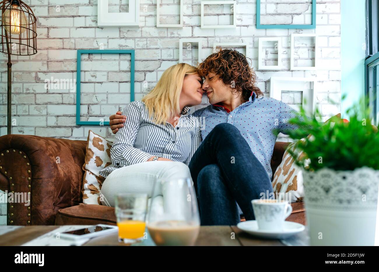 Couple kissing on a sofa Stock Photo