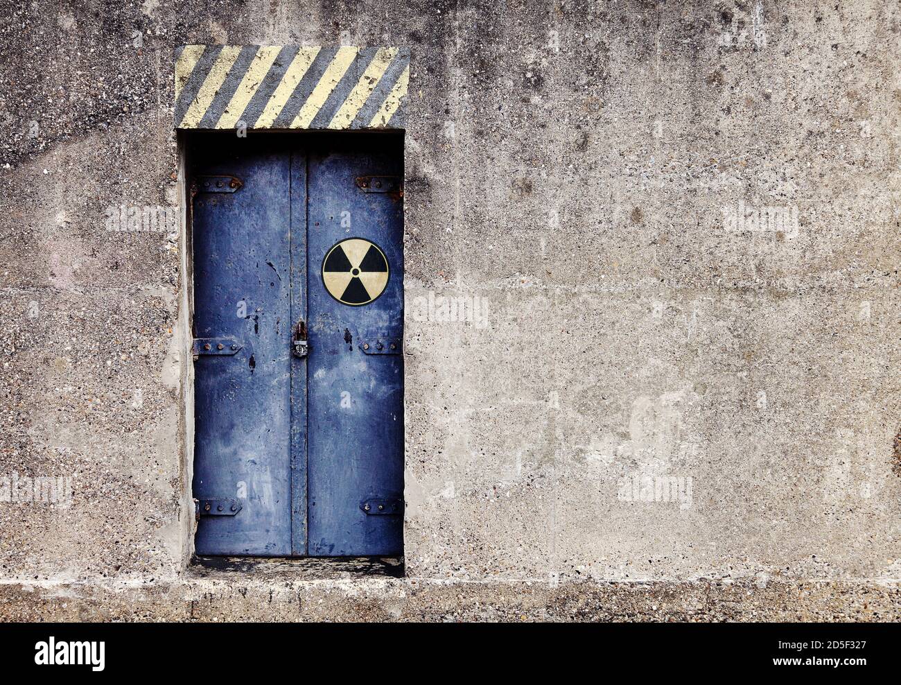 Mysterious padlocked reinforced steel door to a concrete nuclear bunker underground bomb shelter Stock Photo