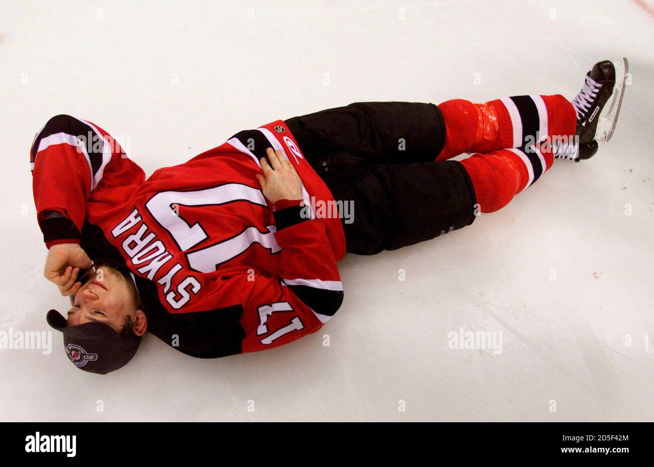 New Jersey Devils' Patrick Elias from the Czech Republic wears the sweater  of injured teammate and countryman Petr Sykora while he lays on the ice  talking on a cell phone after the