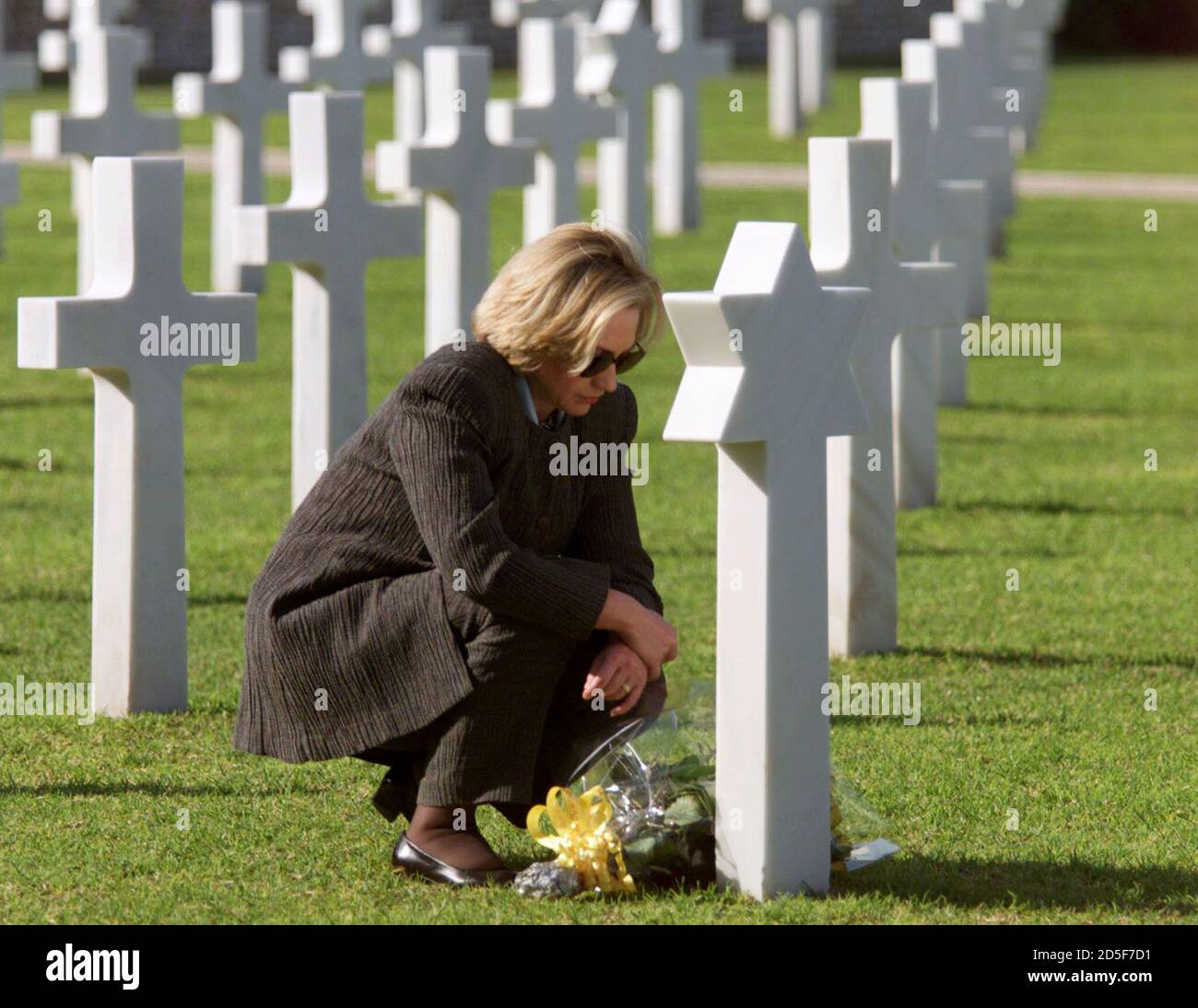 U.S. first lady Hillary Clinton kneels before the grave of U.S. Private  Celia Goldberg, who was killed in Tunisia during World War II, at the North  Africa American Cemetery, outside Tunis March
