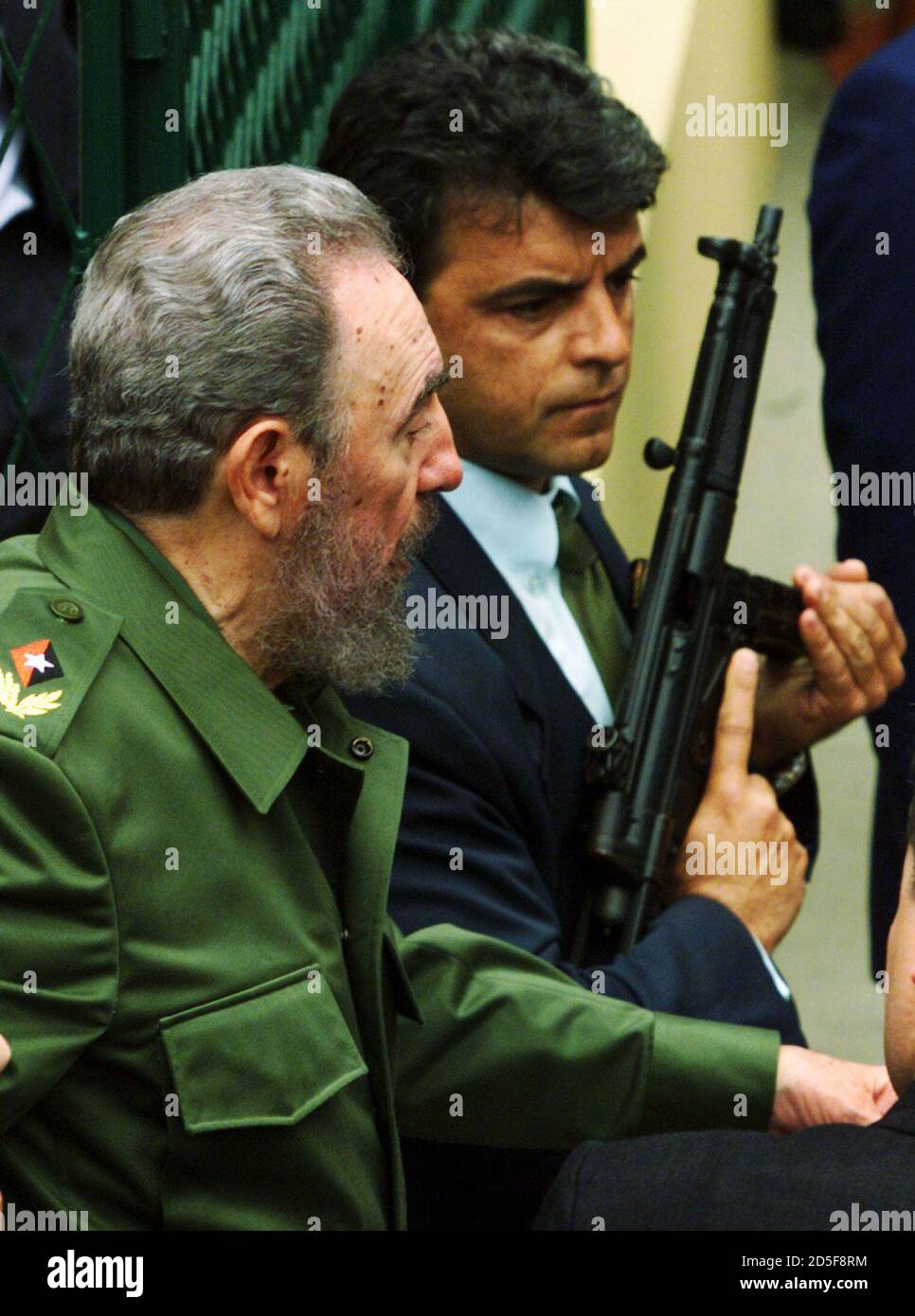 Cuban President Fidel Castro L Walks Past A Federal Police Officer Armed With An Mp 5 Machine Gun After Visiting A Health Clinic In The Town Of Niteroi Near Rio De Janeiro June