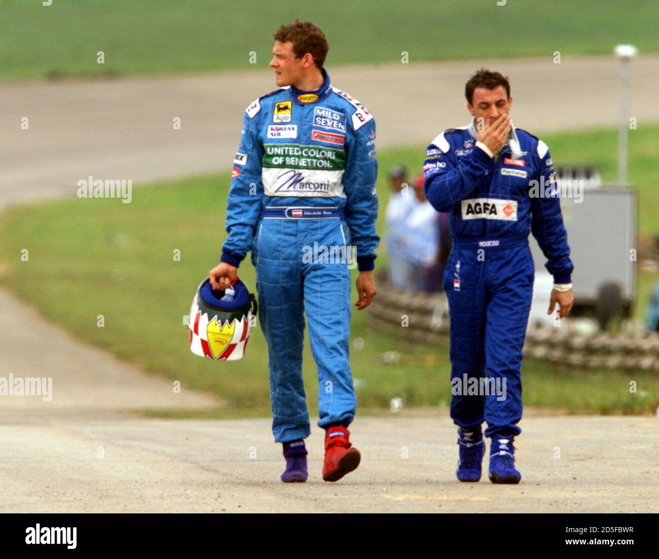 Austrian driver Alexander Wurz (L) of the Benetton racing team and French  driver Jean Alesi of Prost Racing walk along the infield of the Interlagos  race track after their cars crashed out