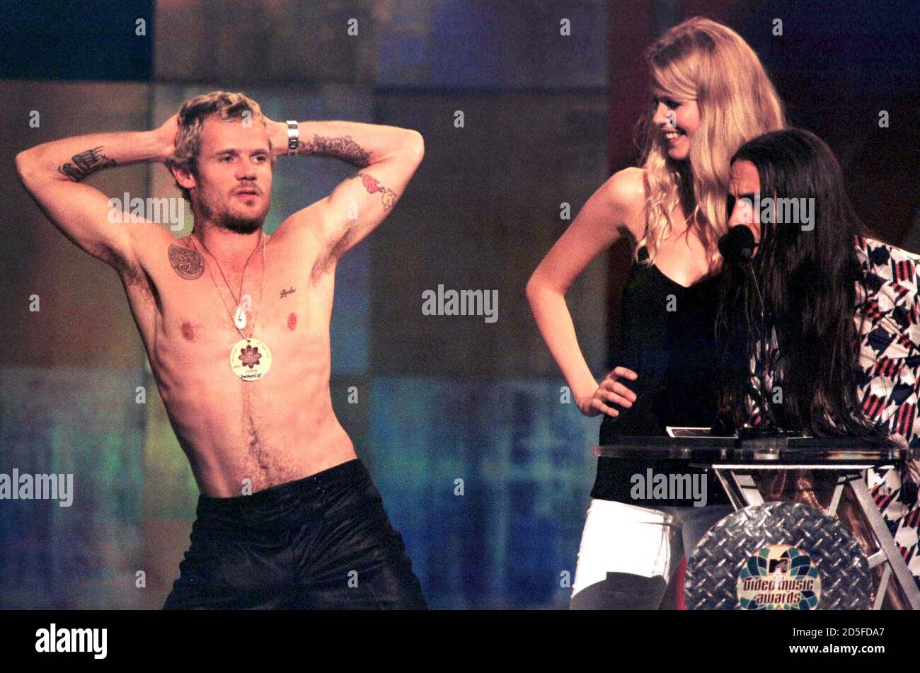 Flea of the Red Hot Chili Peppers (L) dances a strip-tease for model  Claudia Schiffer (C), while fellow bandmember Anthony Kiedis sings at Radio  City Music Hall in New York, September 4,