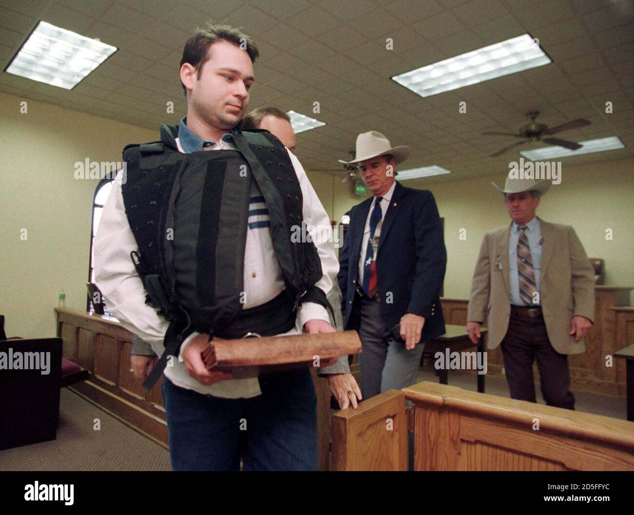 Sheriff Billy Rowles (C) and Texas Ranger Ronnie McBride (R) escort John William 'Bill' King, 24, through a Jasper County Courtroom as the punishment phase of the dragging death trial continued  February 24.  King was found guilty Feb. 23, of capital murder for the death of James Byrd Jr. Stock Photo