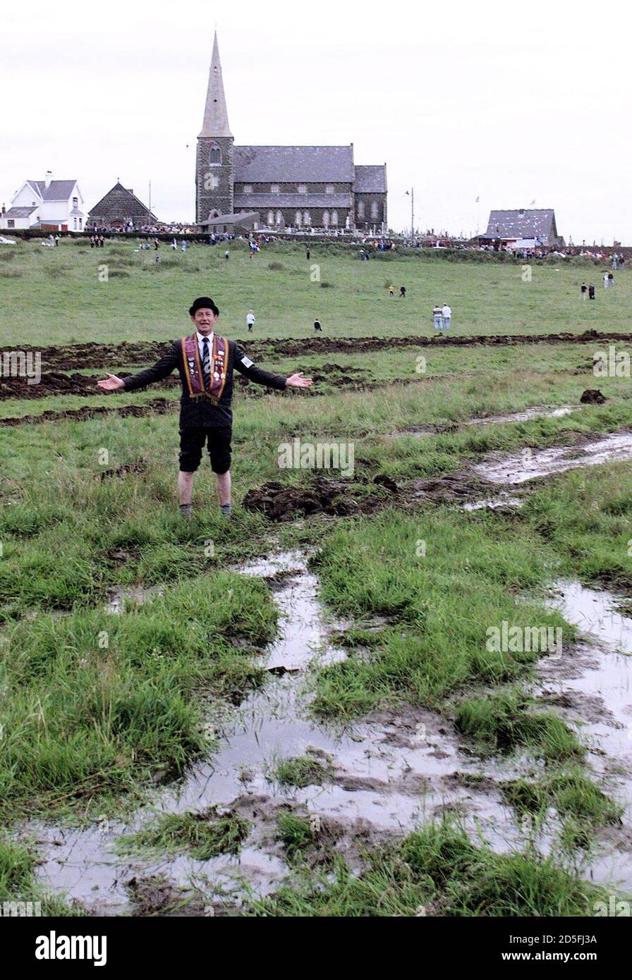 An Orangeman rolls up his trouser legs in the muddy field of Drumcree church in Portadown July 3. The Orange order march from the church down the Garvaghy road this year has been banned by the Parades Commission in Northern Ireland.  DC/kc Stock Photo