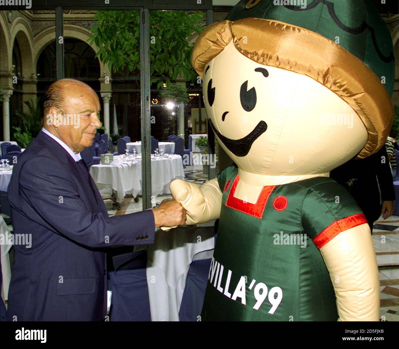 IAAF President Primo Nebiolo is greeted by 'Giraldilla', the mascot for the Seville '99 World Athletics championships, upon arriving at a Seville hotel for an IAAF meeting August 16. The seventh IAAF world championships will take place in Seville from August 21 to 29. **DIGITAL IMAGE** Stock Photo
