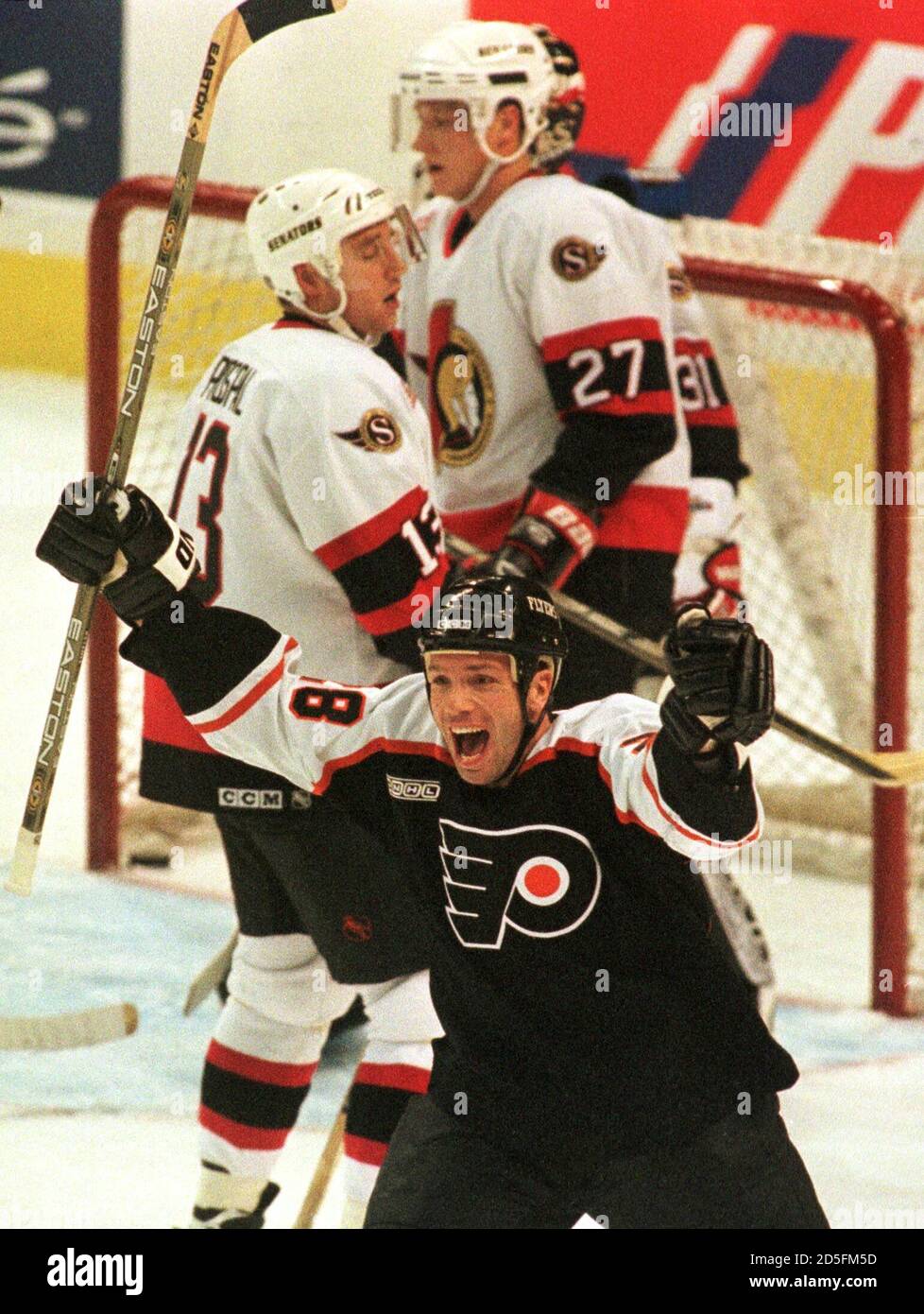Philadelphia Flyers' Marc Bureau (28) celebrates his team's goal as Ottawa  Senators' Vaclav Prospal (L) and Janne Laukkanen (R) skate past dejectedly  during first period NHL action in Ottawa, November 28. Bureau