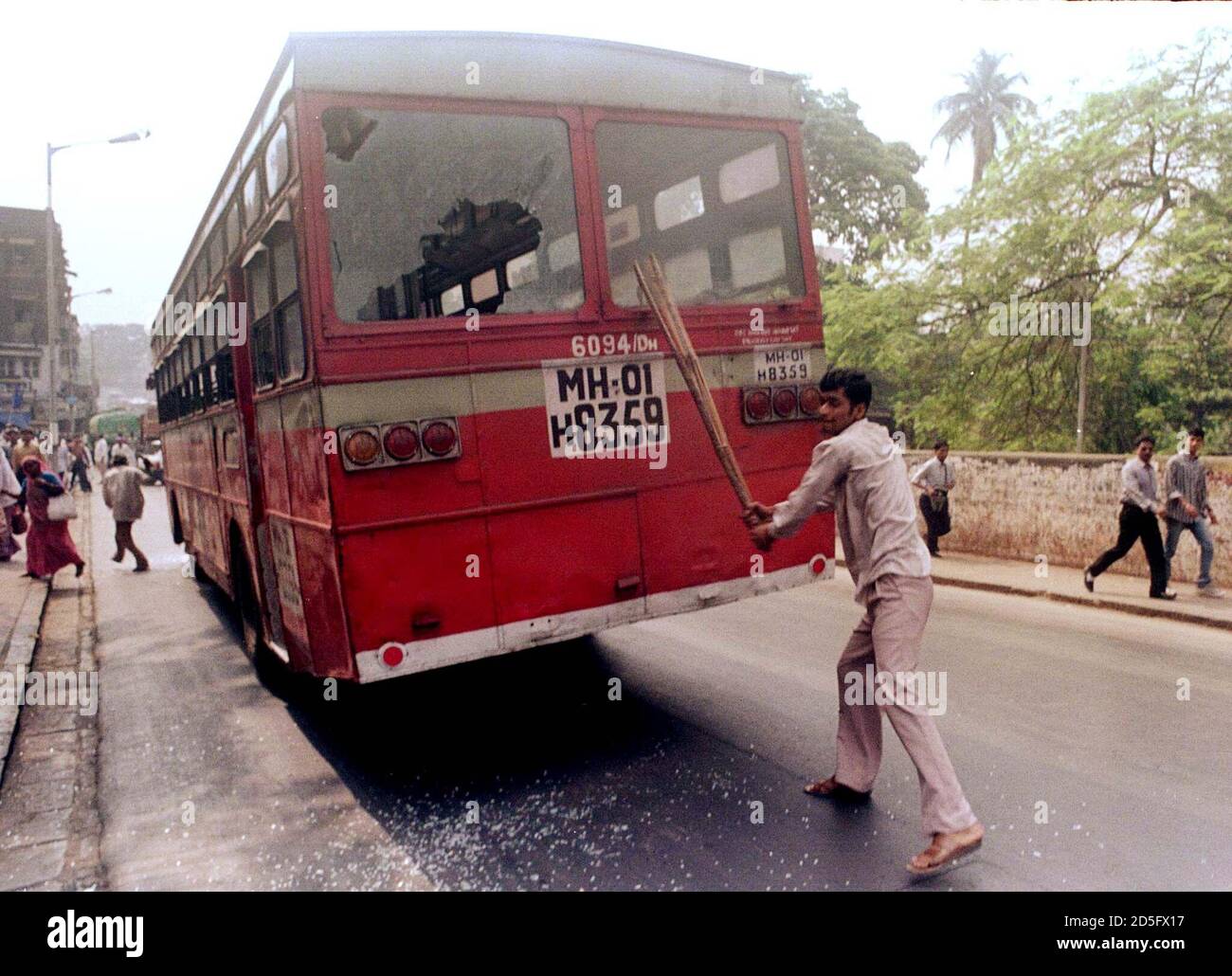An activist from the Party India (RPI) breaks the windows of a public service bus in Bombay, April 2 to enforce a strike following the death of a party