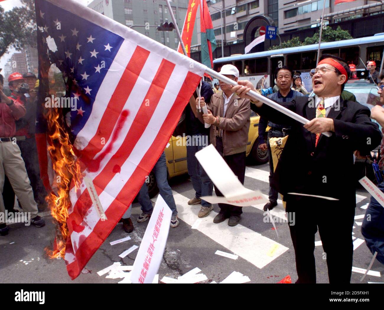 A pro-Chinese Labour Party supporter holds a burning American flag outside  the Taipei office of the American Institute in Taiwan (AIT) May 10. About  100 angry protesters rallied outside the AIT office