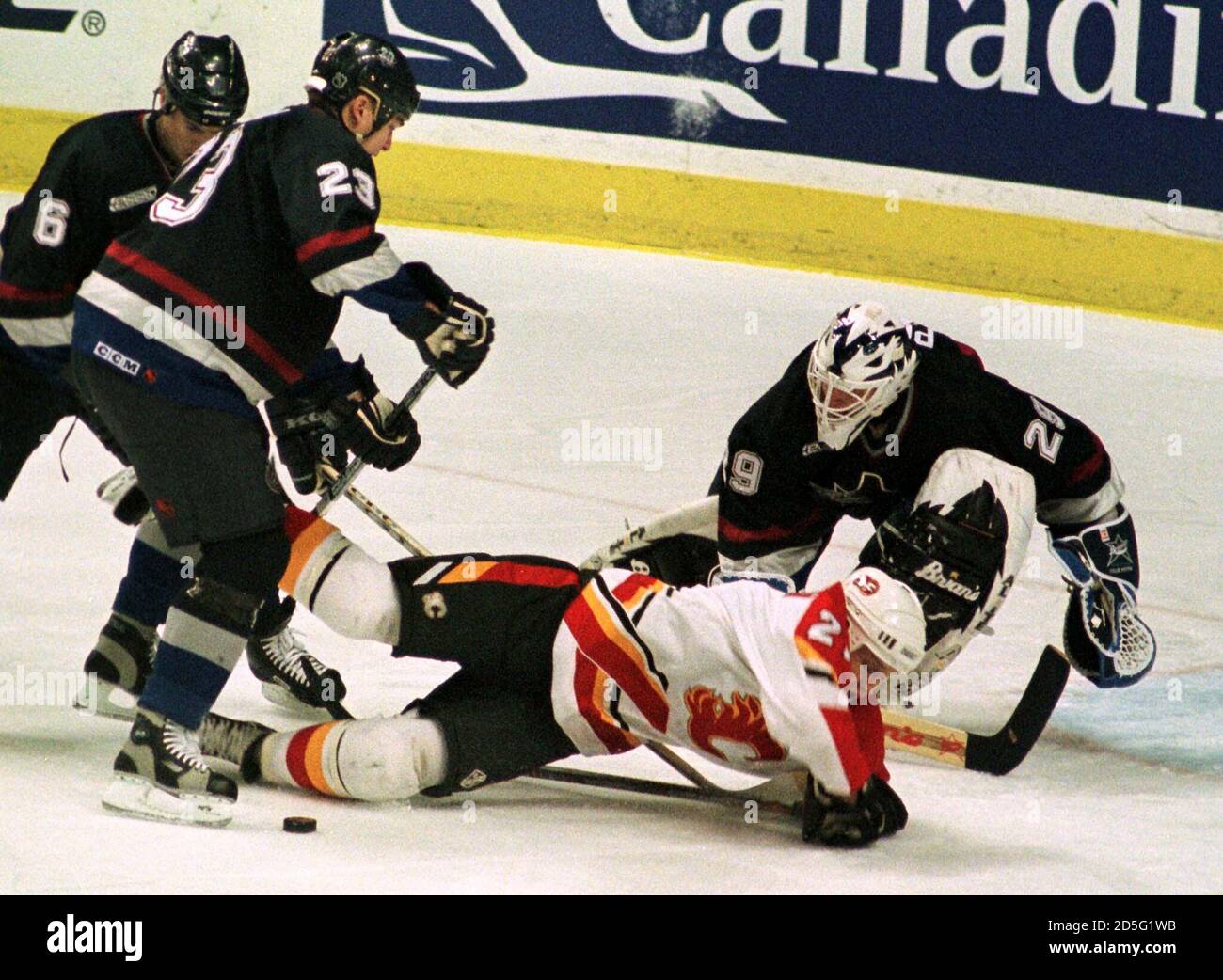 Calgary Flames Forward Andreas Johansson 21 Is Cross Checked By Vancouver Canucks Defenseman Murray Baron 23 In Front Of Vancouver Goalie Felix Potvin January 2 In Calgary Baron Received A Minor Cross Checking Penalty