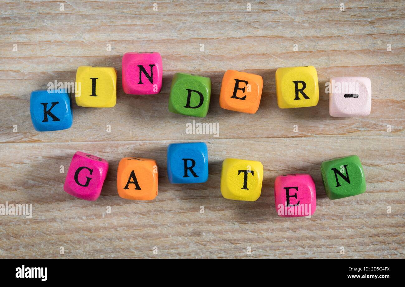 Kindergarten letter cubes concept on wooden background. Stock Photo
