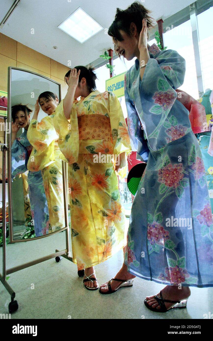 Kimono retailer employees Hiroko Takeda (R) and Hiroko Otsuka check out new  "see-through yukata" summer kimonos at Suzunoya store in Tokyo April 10.  The cool and trendy garment is made of polyester