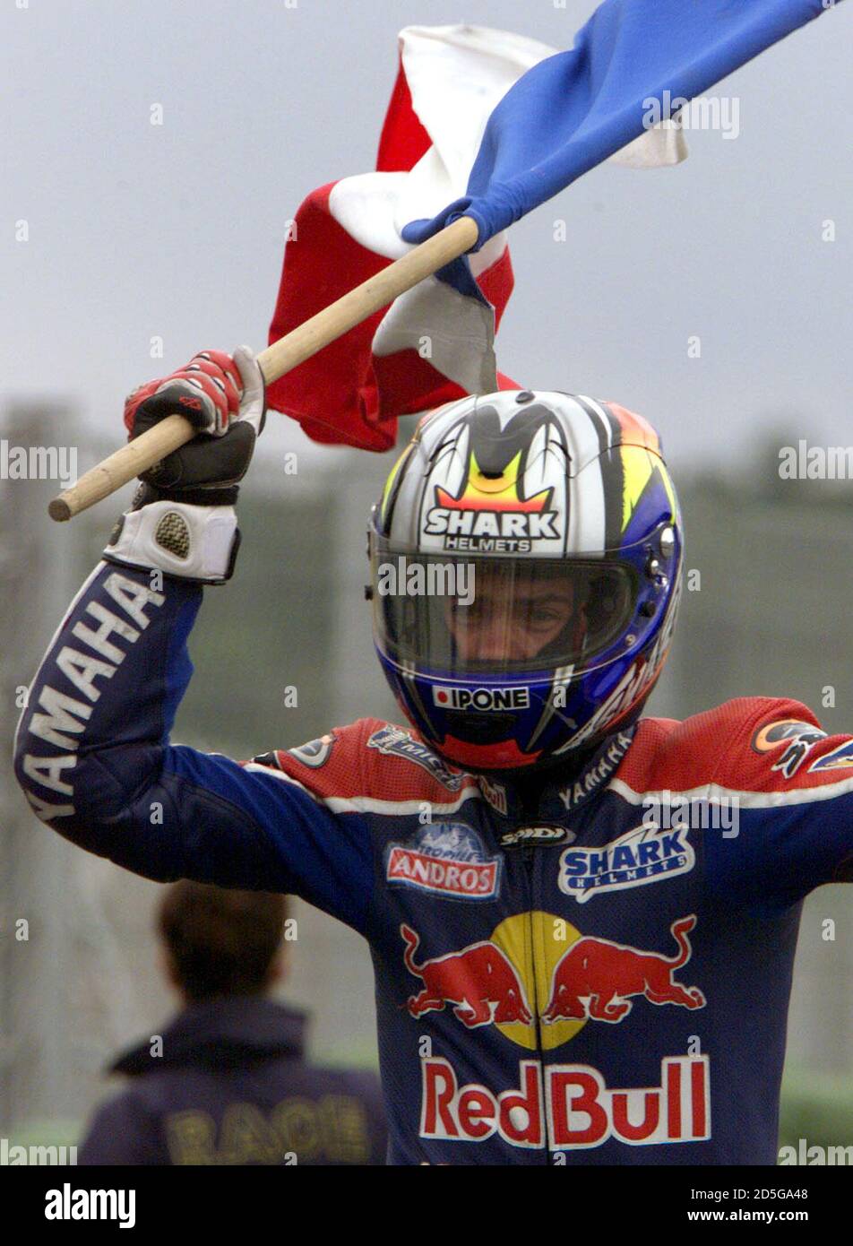French 500cc class rider Regis Laconi waves a flag after winning the Road  Racing World Championship Grand Prix race September 19 in Valencia. [Laconi  came first and Kenny Roberts of the US