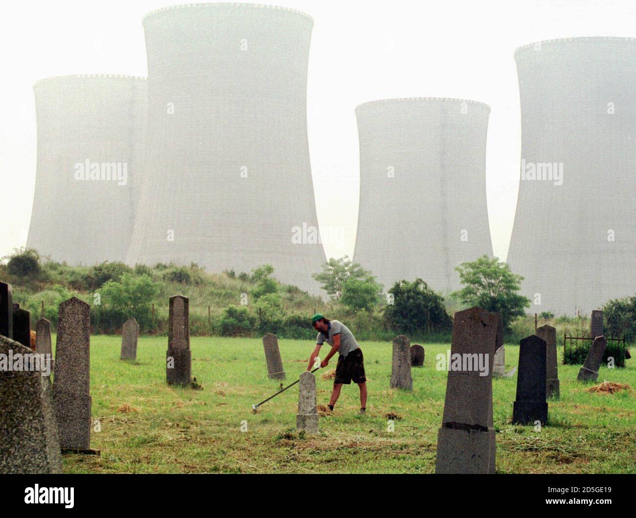 A public worker cuts weeds and cleans Mochovce's cemetary June 9, the last remaining place of the old village Mochovce where Slovakia built a contraversial nuclear powerstation. The plant was activated on Monday, sparking sharp criticism by Austria which fears the plant is unsafe.  JK/AA Stock Photo