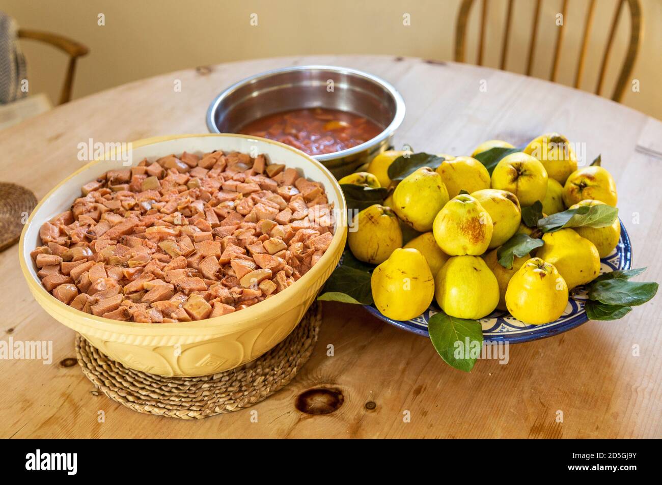 Bowls of quince fruit from garden and chopped fruits prepared for making jam jelly, UK Stock Photo