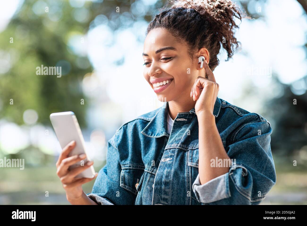 Side View Pleasant Millennial Mixed Race Woman Holding Smartphone