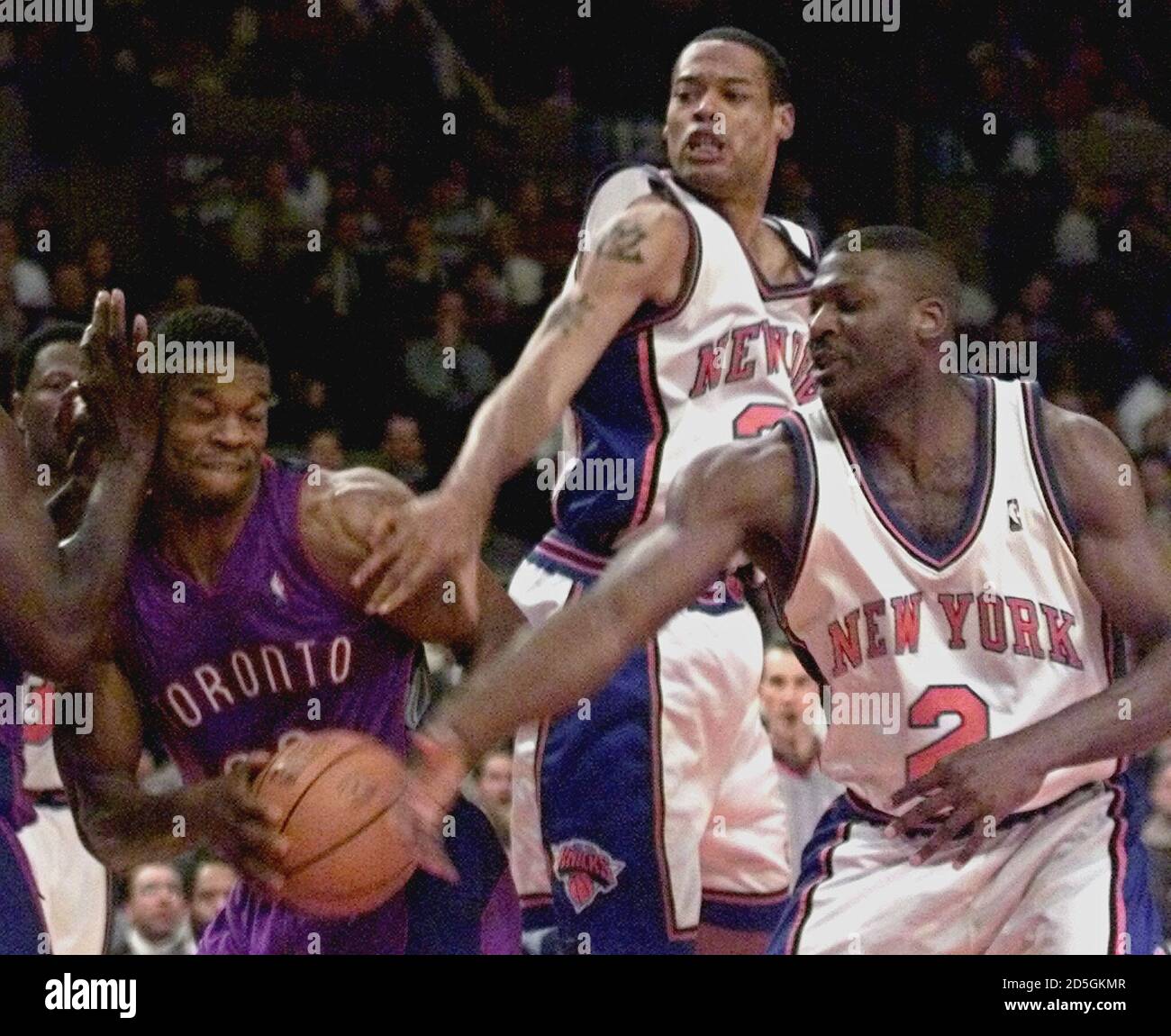 Toronto Raptors forward Charles Oakley (L) grabs the rebound in front of  New York Knicks forwards Marcus Camby (C) and Larry Johnson in the first  period December 22 at New York's Madison
