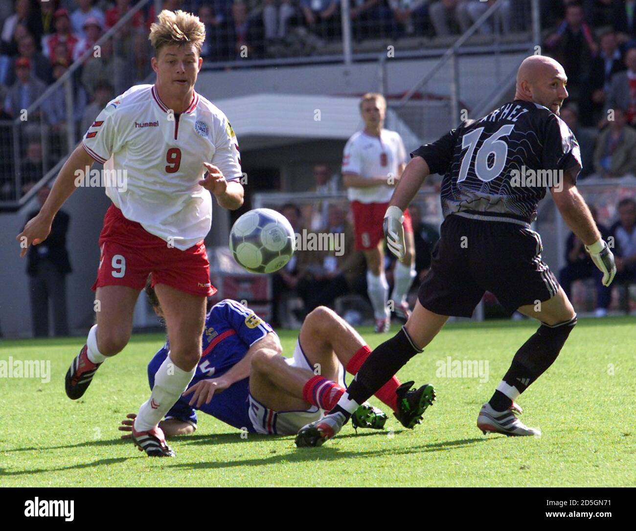 Denmark S Jon Dahl Tomasson L Runs With The Ball As French Goalkeeper Fabien Barthez R Runs Back To His Goal And Teammate Laurent Blanc Lays On The Ground During Their European Championship
