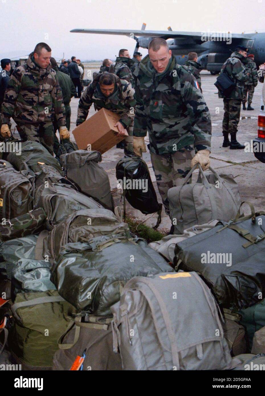 French NATO soldiers collect their belongings piled up on the runway following the arrival of some 40 French troops, members of the NATO extraction force at Skopje airport December 6. The NATO alliance on Saturday announced the imminent deployment to Macedonia of a 1,500-man extraction force to rescue international observers in neighbouring Kosovo in case of emergency. A NATO statement said the mission was in line with United Nations Security Council Resolution 1203 which stipulates arrangements for verifying Yugoslav compliance with U.N. demands to end the Kosovo conflict.  PEK/WS Stock Photo