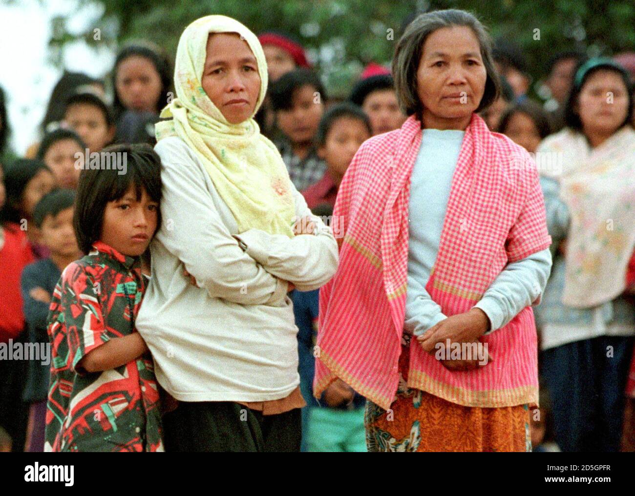 Mea Son (R), the widow of late notorious Khmer Rouge leader Pol Pot, stands  next to an unidentified relative and her daughter (L) as they watch  Cambodian refugees leaving Phu Noi refugee