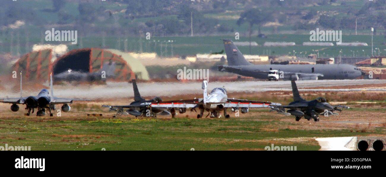 Two U.S. F16 fighter planes move past a U.S. Prowler radar jamming