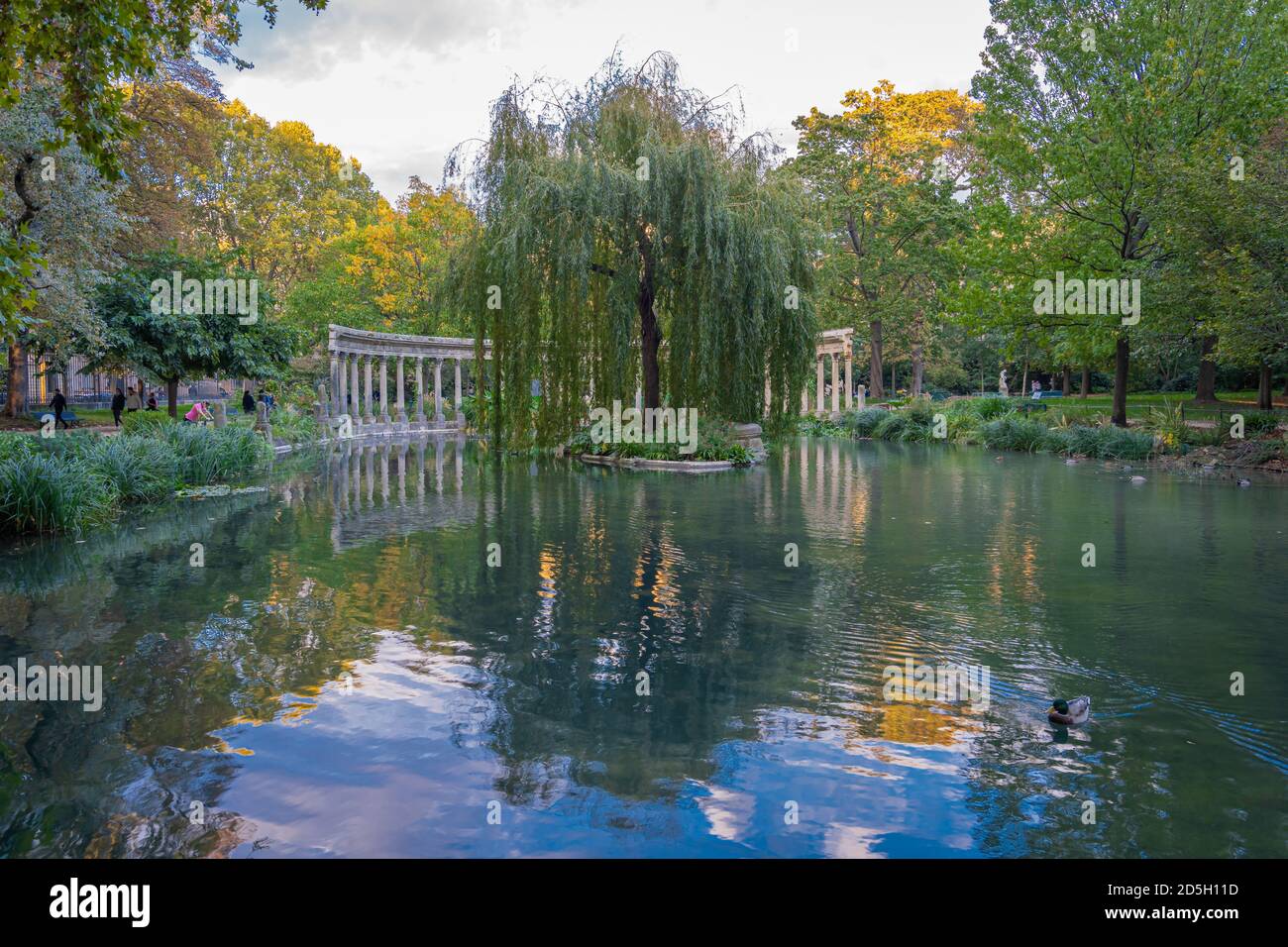 Paris, France - 10 11 2020: Golden hour in Parc Monceau in autumn. Oval basin bordered by a Corinthian colonnade Stock Photo