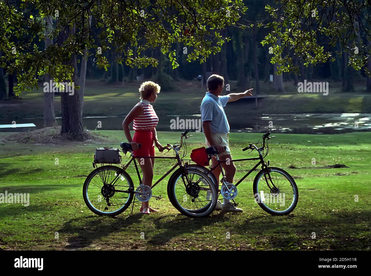 Adult male and female with bicycles ride for exercise and pleasure Stock Photo