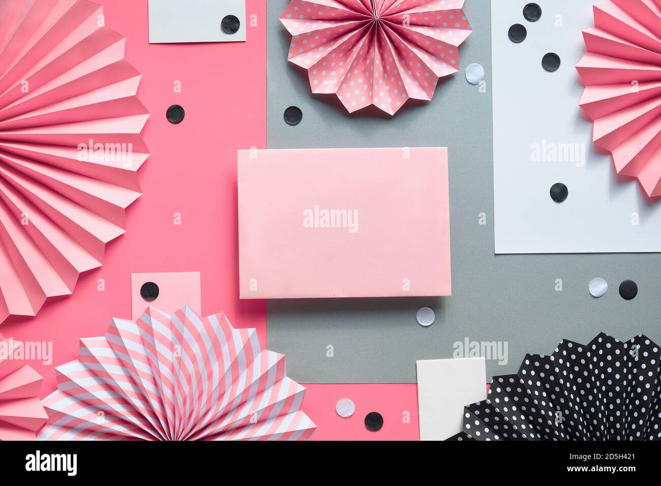 Pink paper frame with folded paper fans and confetti on black, pink ...